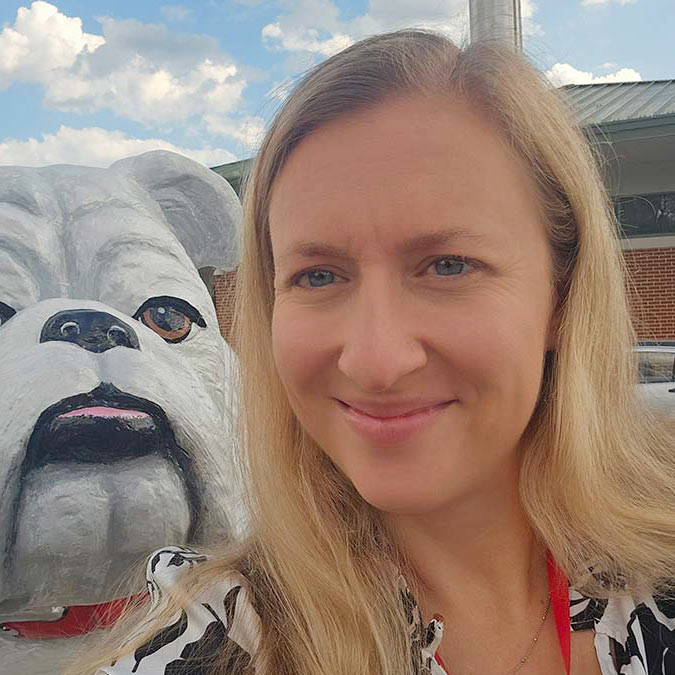 Jessica Barnes taking a selfie in front of a Bulldog statue at the school where she teaches.