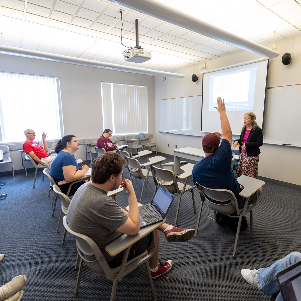 Students raise their hands to respond to a question during a history seminar taught by Dr. Michelle Morgan.