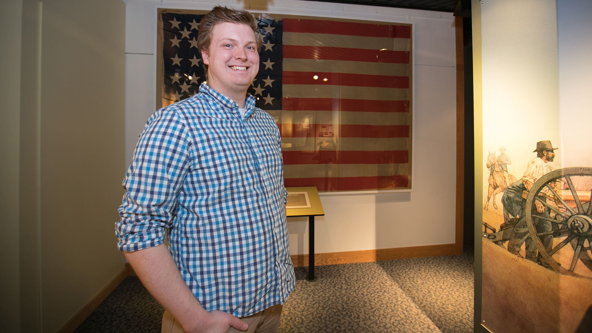 Paul Rehagen, a history major, in front of a U.S. flag at Wilson's Creek Battlefield.