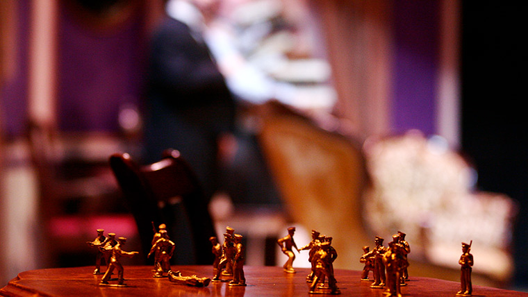 Toy soldier figurines on a table depicting a battle.