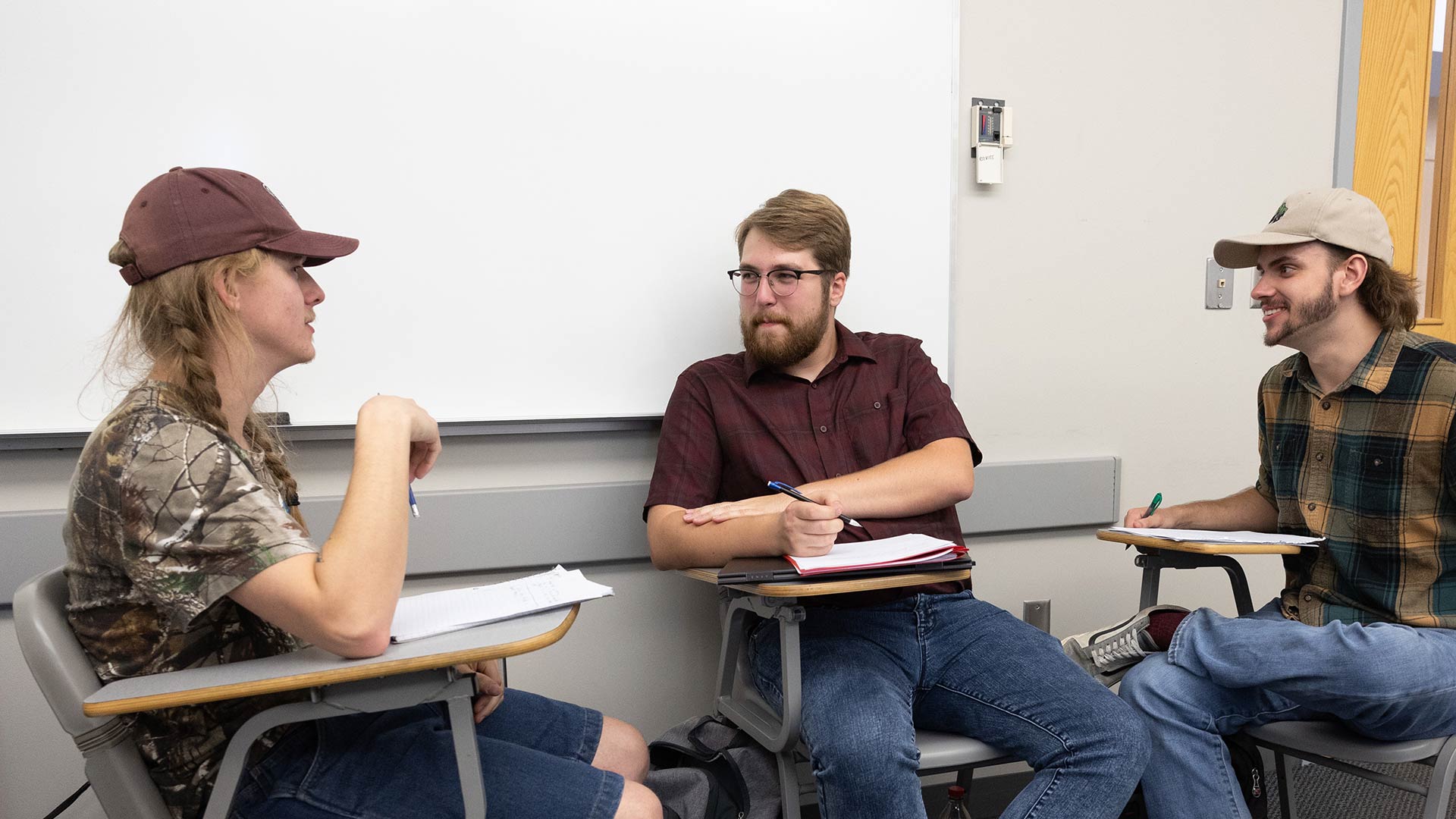 Three history education majors having a group discussion in class.