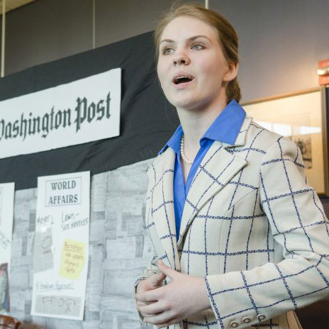 A student presenting her poster board at National History Day.