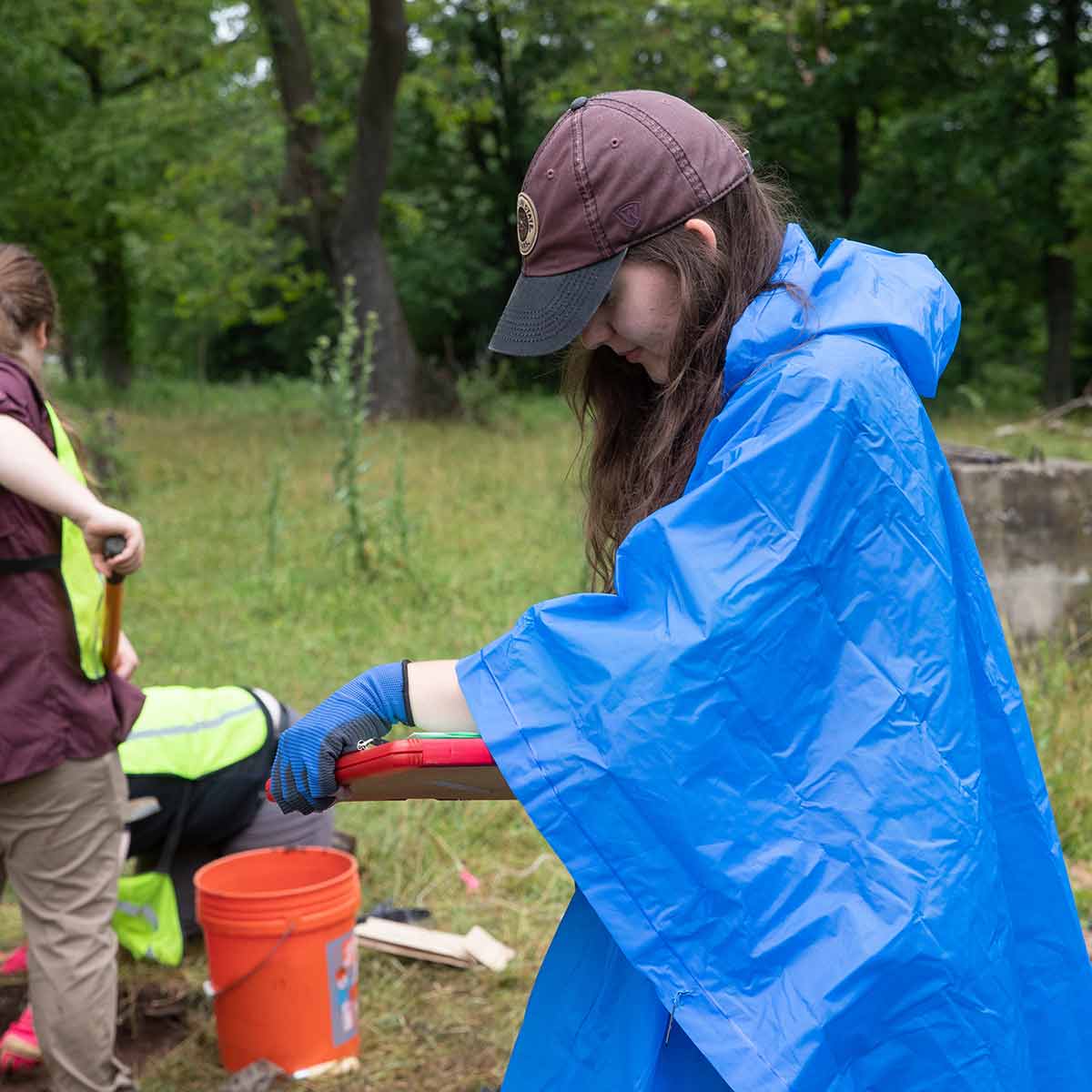 Two students working at a historical site during an archaeological dig.