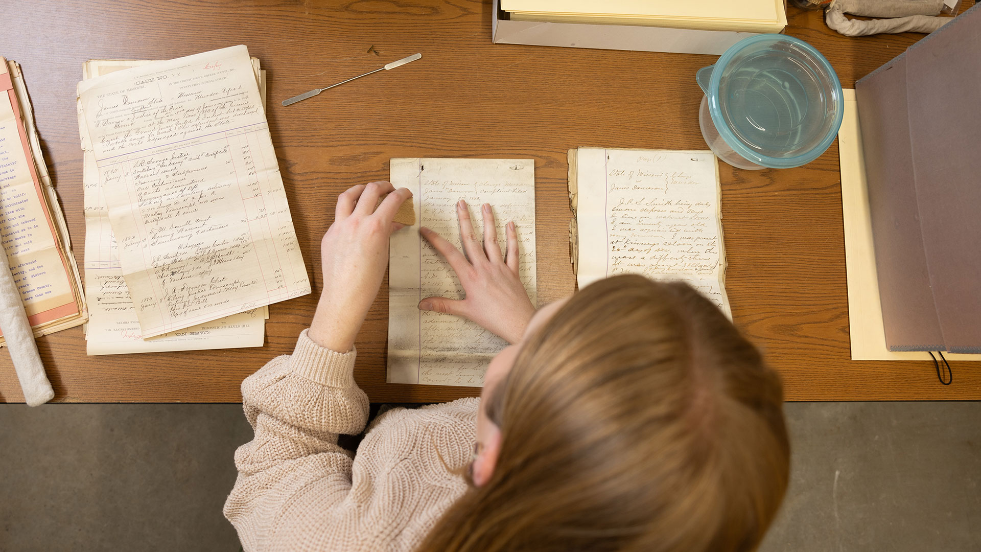 Susan Hardy, a history intern at the Greene County Archives, preserves a historical document.