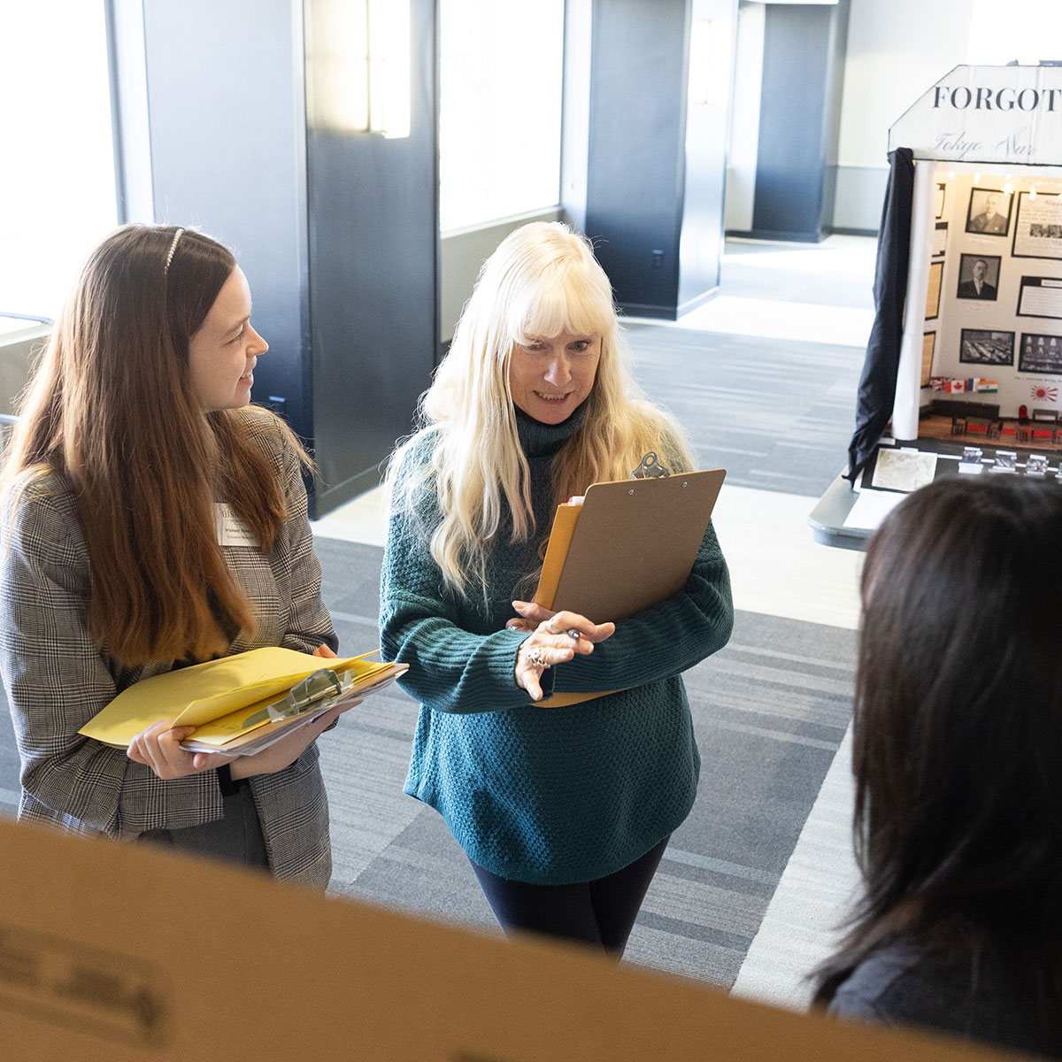 Two judges give feedback to a student on National History Day.