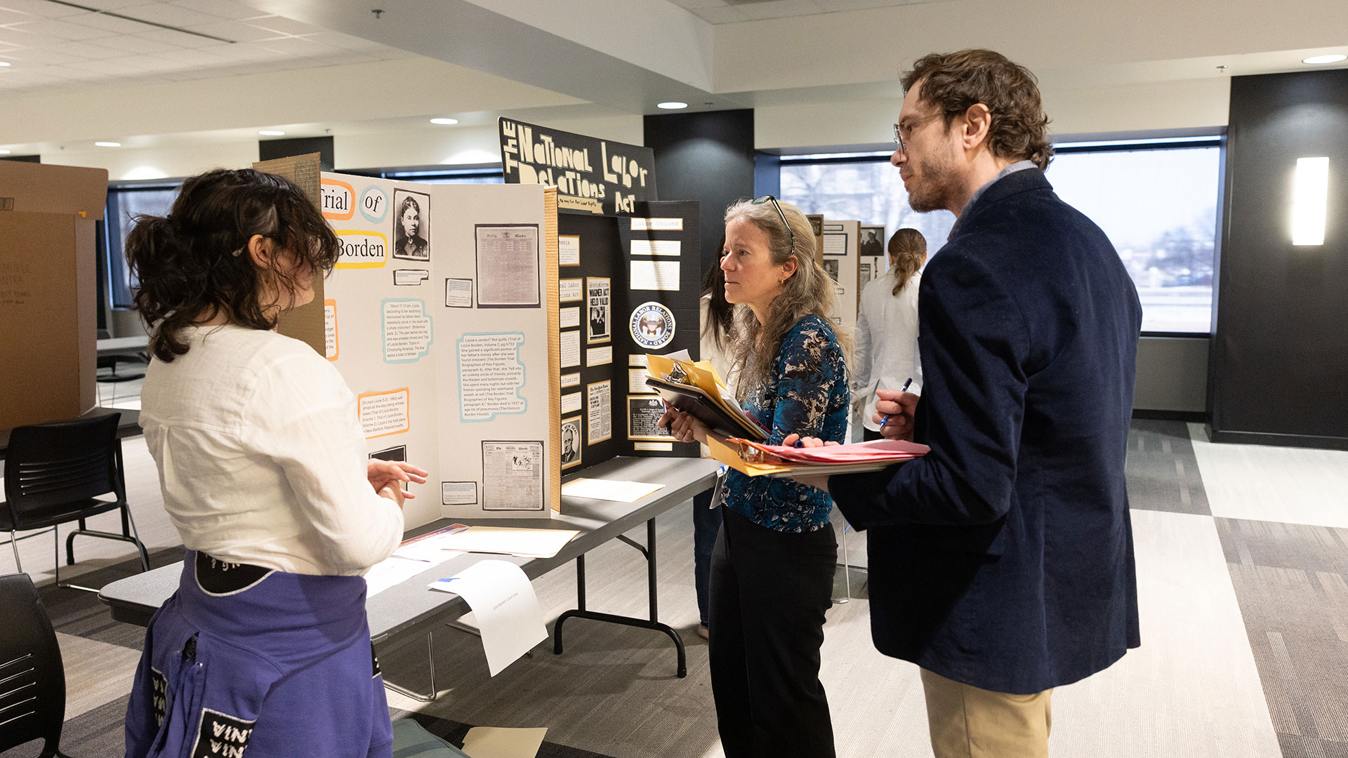 A student presents her project to two judges during National History Day.